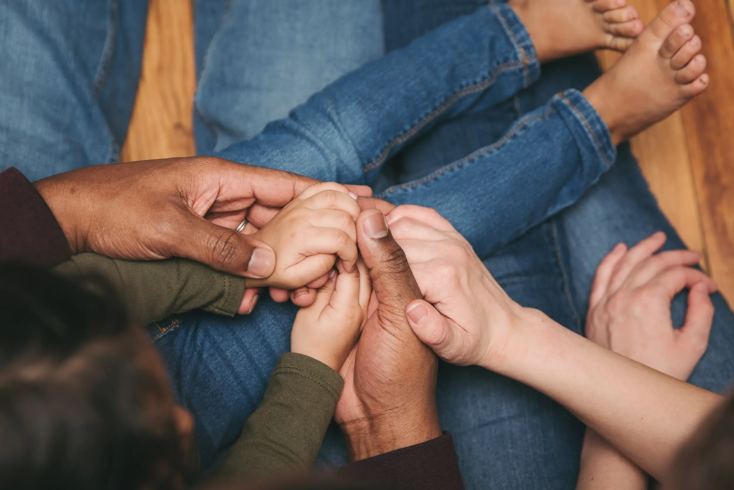 Family holding hands at home